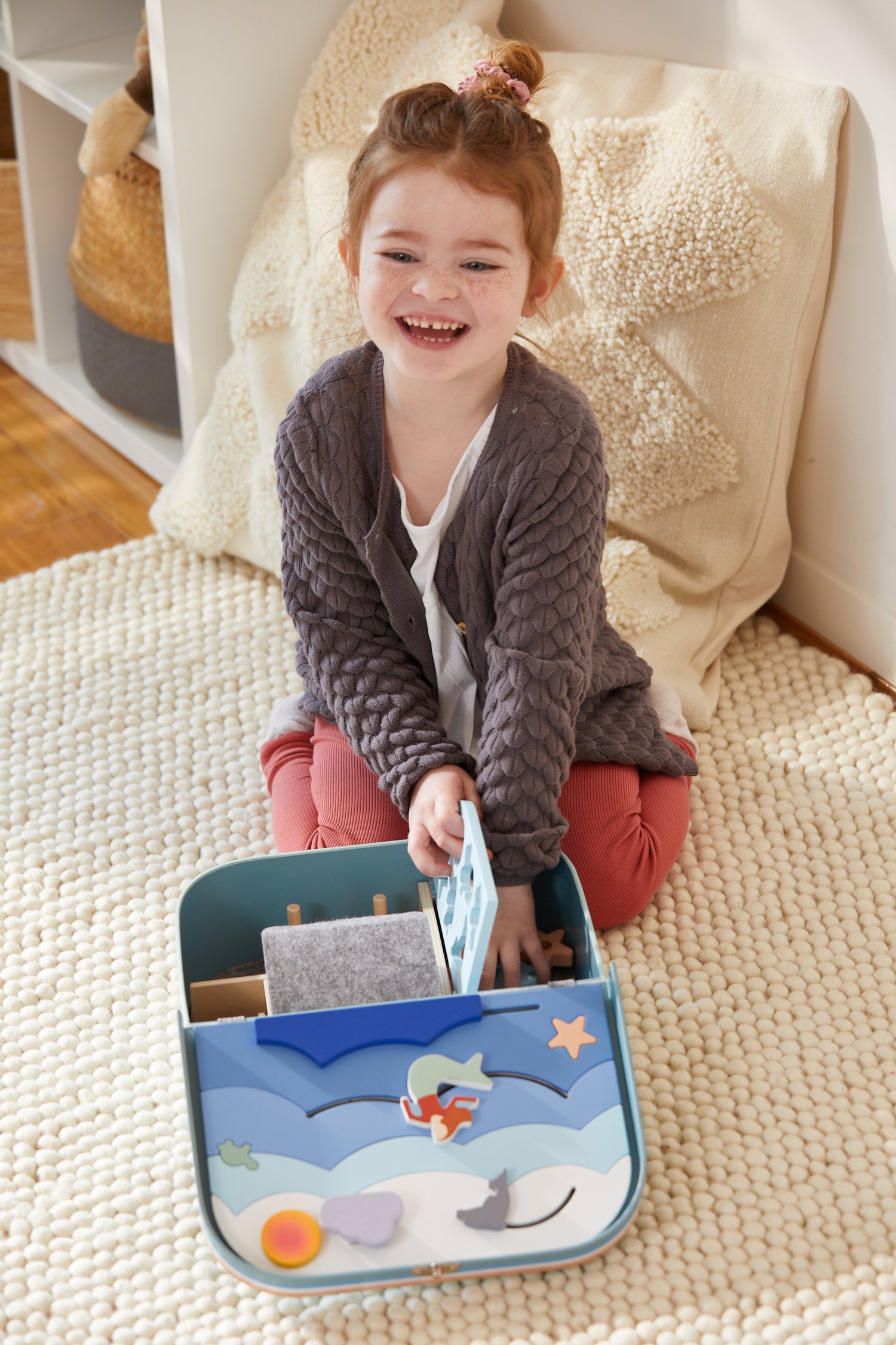 Girl (3+ years)playing with an educational toy suitcase (ocean theme). Made of sustainable materials & produced ethically. Supports child development (imaginative play, problem solving, cognitive and fine motor skills..), designed in Australia.